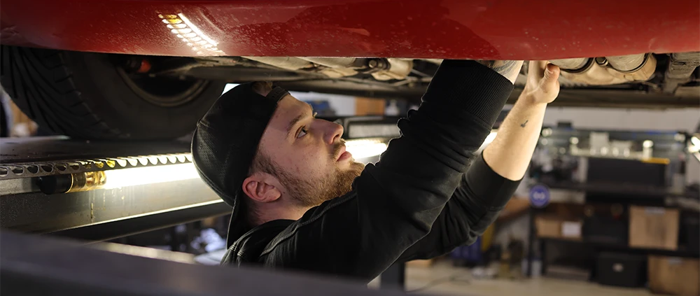 Impressionen aus der Werkstatt, Emilia Auto Service, Sascha Seibert bei der Arbeit unter dem Auto